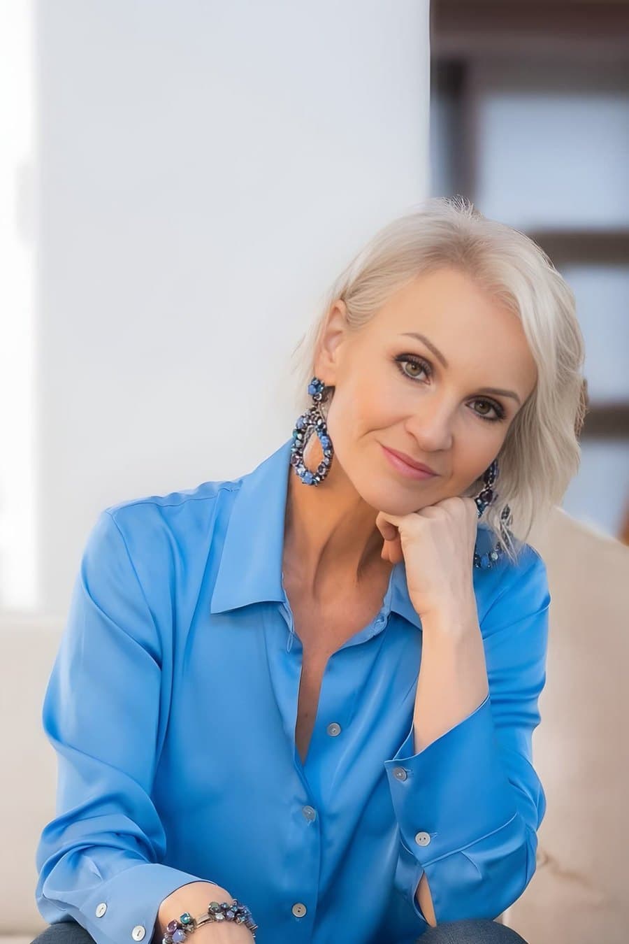 Linda Paige seated in navy silk — a word from your Dauntless coach